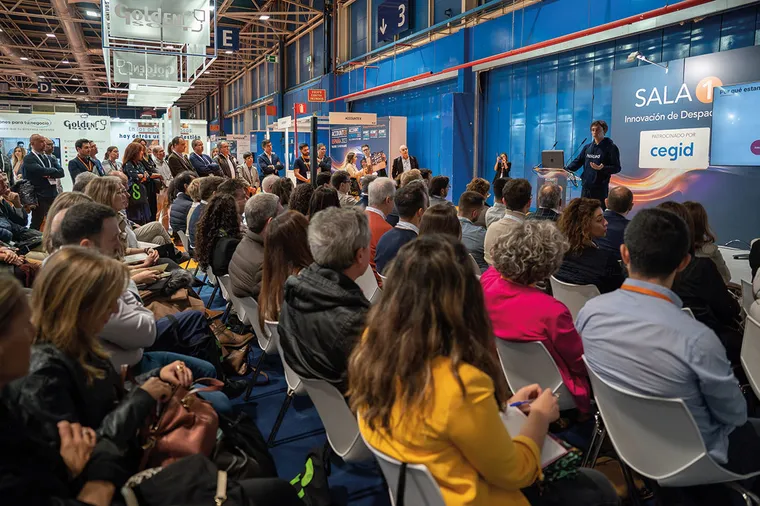 Ponentes y público en una presentación con apoyo audiovisual