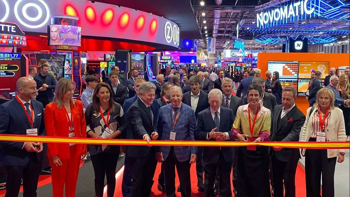Visitantes en un stand con rótulo Novomatic