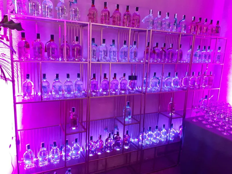 Expositor de botellas iluminado con luz violeta
