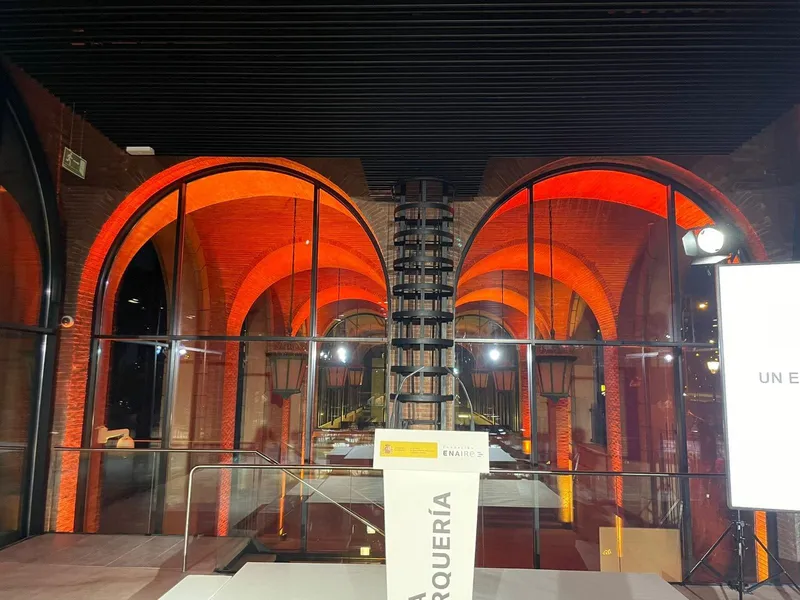 Arcos de ladrillo iluminados en naranja junto a un atril