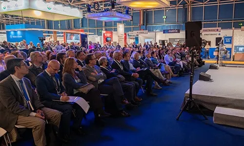 Ponentes y público en una presentación con apoyo audiovisual