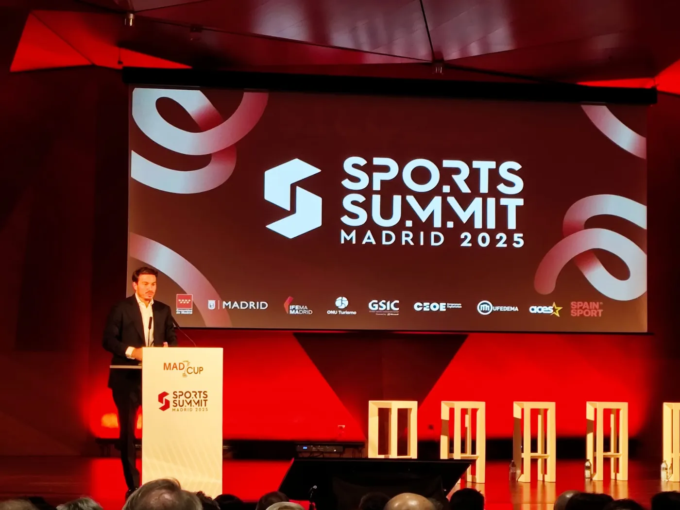 Ponentes y público en una presentación con apoyo audiovisual